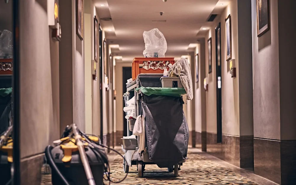 A housekeeping trolley loaded with supplies in a corridor.
