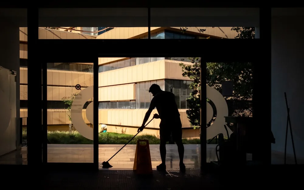 A cleaner mopping the floor of a newly finished room.