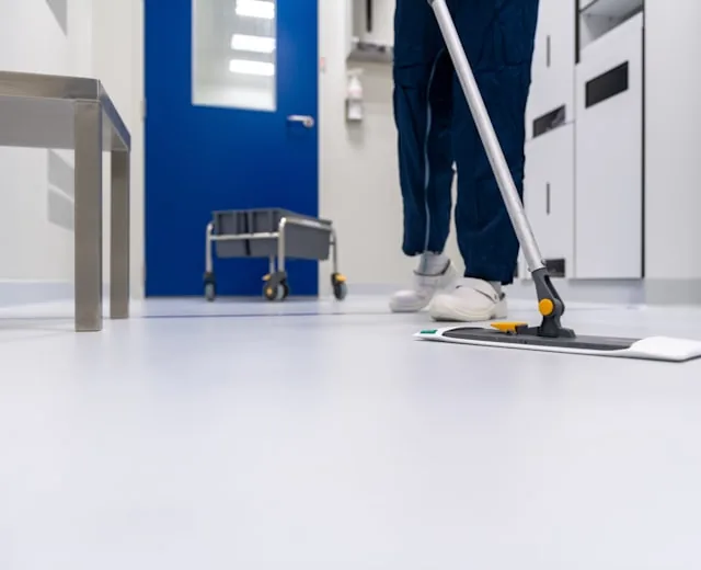 A cleaner mopping the floor of a Nottingham office corridor.